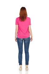 Rear Side View Of Standing Young Casual Woman