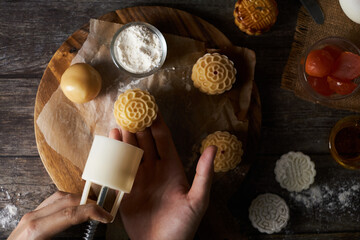 Chef hand making Mooncake a Chinese traditional pastry for Mid-Autumn festival. set on rustic...
