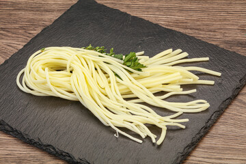 Chechil spaghetti cheese over board