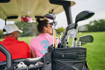 Two Caucasian people sitting in a vehicle