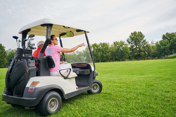 Two people sitting in a vehicle parked on the lawn