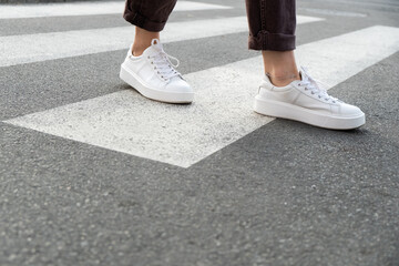 female feet crossing the crosswalk