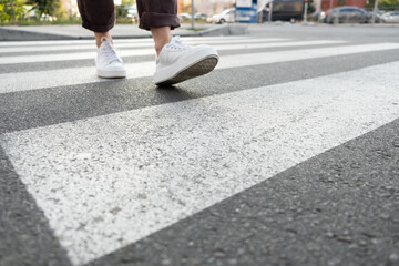 female feet crossing the crosswalk