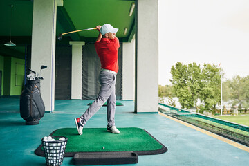 Sportsman swinging his club during the workout