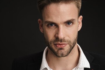 Handsome confident businessman posing and looking at camera