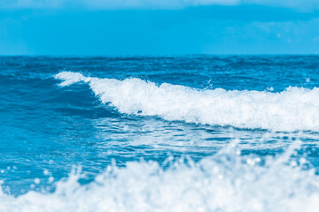 Water wave splash on blue sea background.