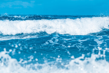 Naklejka na ściany i meble Water wave splash on blue sea background.