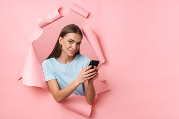 Young caucasian brunette woman smiling and holding cellphone