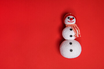 Festive christmas background with knitted and smiling snowman wearing a scarf and hat