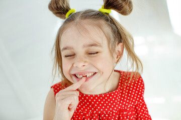 A beautiful little girl lost the first milk tooth. Loss of primary teeth, replacement of teeth with...