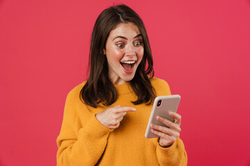 Excited young woman holding mobile phone