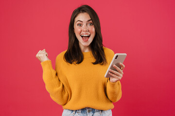 Excited young woman holding mobile phone