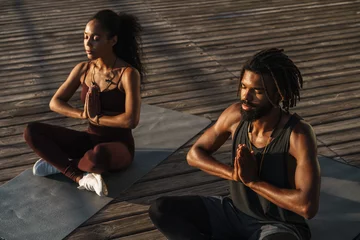  Calm afro american couple doing yoga exercises © Drobot Dean