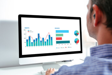 Business man working on computer with financial data on the screen