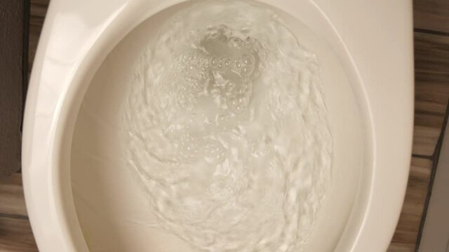 A rotating shot of flushing a toilet