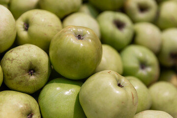 Lots of green apples on the counter. Healthy food and vitamins.