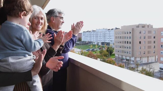 4k video of mother, son and grandparents clapping on the balcony