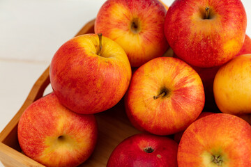 Pile of red apples on wooden tray
