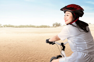 Asian woman with a bicycle helmet riding a bicycle