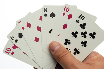 A man's hand holds six playing cards of different colors and suits. Photographed on a white background with clipping