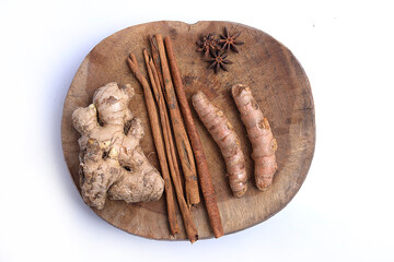 Fresh turmeric and ginger with cinnamon sticks on wooden