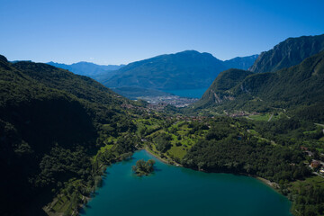 Obraz premium Turquoise lake in the mountains. Lake Garda in the background. Mountain lake in the alps of Italy. Aerial view of Lake Tenno in autumn, Trento, Italy, Europa.