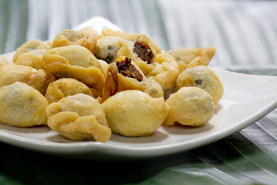 Fried flour molding thai ancient dessert which has fish filling stuffed, (Thai called "Pan klib") in white dish on banana leaf