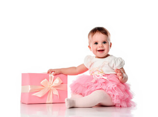 girl sitting on the floor with a gift box and smiling.