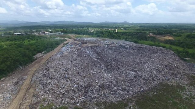 Bulldozers in Duquesa landfill and people collecting waste. Aerial view
