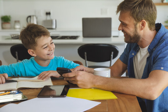 Man helping son with homework at home