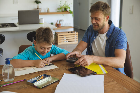 Man helping son with homework at home