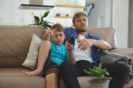 Man and son watching TV at home