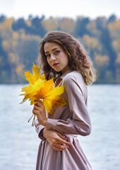 Beautiful girl with autumn leaves. October photos of autumn.