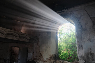 Sunlight shining throuh the windows of an old abandoned church building
