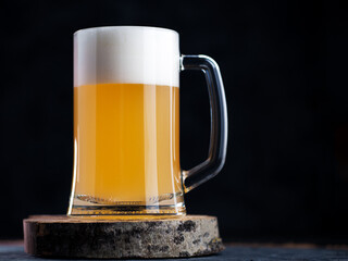 Glass mug of wheat foam beer on a dark background