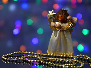 New Year's angel and beads on a Christmas background.