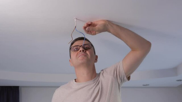 A male employee bites off the insulation from an electrical wire