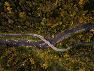 Obraz na płótnie Canvas Winding Road and River in Autumn Forest. Aerial Drone Top Down View. Bieszczady in Poland