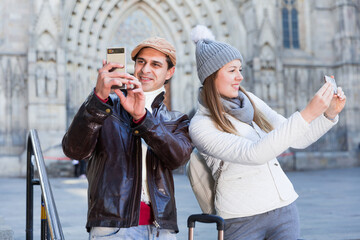 Smiling couple man and woman in the historic center taking selfie