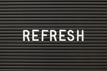 Black color felt letter board with white alphabet in word refresh background