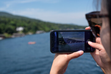 chinese woman taking pictures of lake george new york