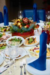 Table setting with white plates , blue serviettes and cutlery on table, copy space. Place setting at Christmas party. Table served for New year banquet in restaurant