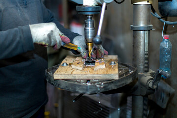 The hands of a mechanic grinder in gloves at work