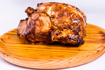 Roast chicken on a wooden tray on white background