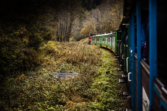 Retro Train Trough Wilderness of Bieszczady Mountains in Poland at Autumn. Dramatic Weather and Moody Toned Colors.