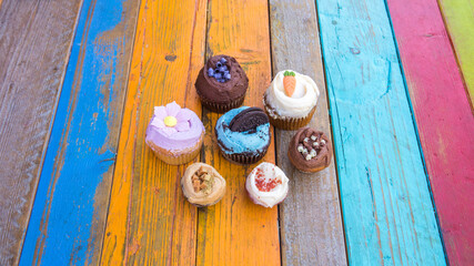 Colorful and tasty cupcakes on a colorful wood table