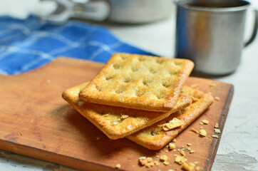 Cracker and coffee on the wooden chopping board on the table
