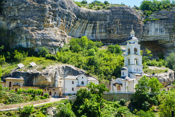 Buildings of Assumption Cave Monastery & its bell tower, Bakhchysarai, Crimea. Complex located on bottom of canyon (as it seen on background). It was founded in VIII AD