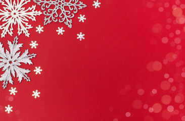 Fototapeta na wymiar Christmas and New Year background with snowflakes decorations. Trendy Christmas greeting card whith copy space on red background. Top view, flat lay.