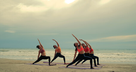 Professional group females yoga practice in class on mat stretching